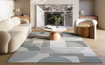 Moderne stue med grafisk designteppe i duse grønntoner og rene linjer – en stilren og balansert interiørløsning.