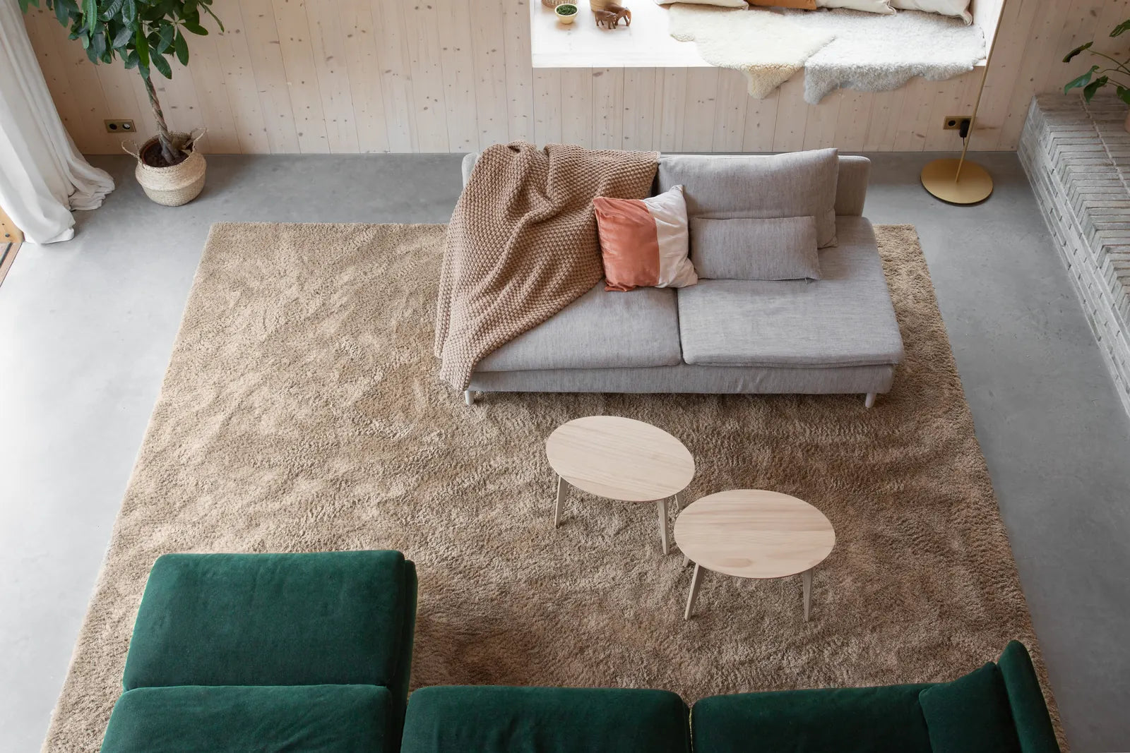 Måltilpasset Golvabia-teppe i varm beige under en sofagruppe